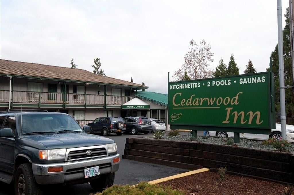 A Cedarwood Inn sign with amenities including kitchens, 2 pools, and saunas.