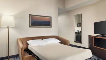 Une chambre d’hôtel avec un lit, une lampe, un tableau, un miroir et un téléviseur.