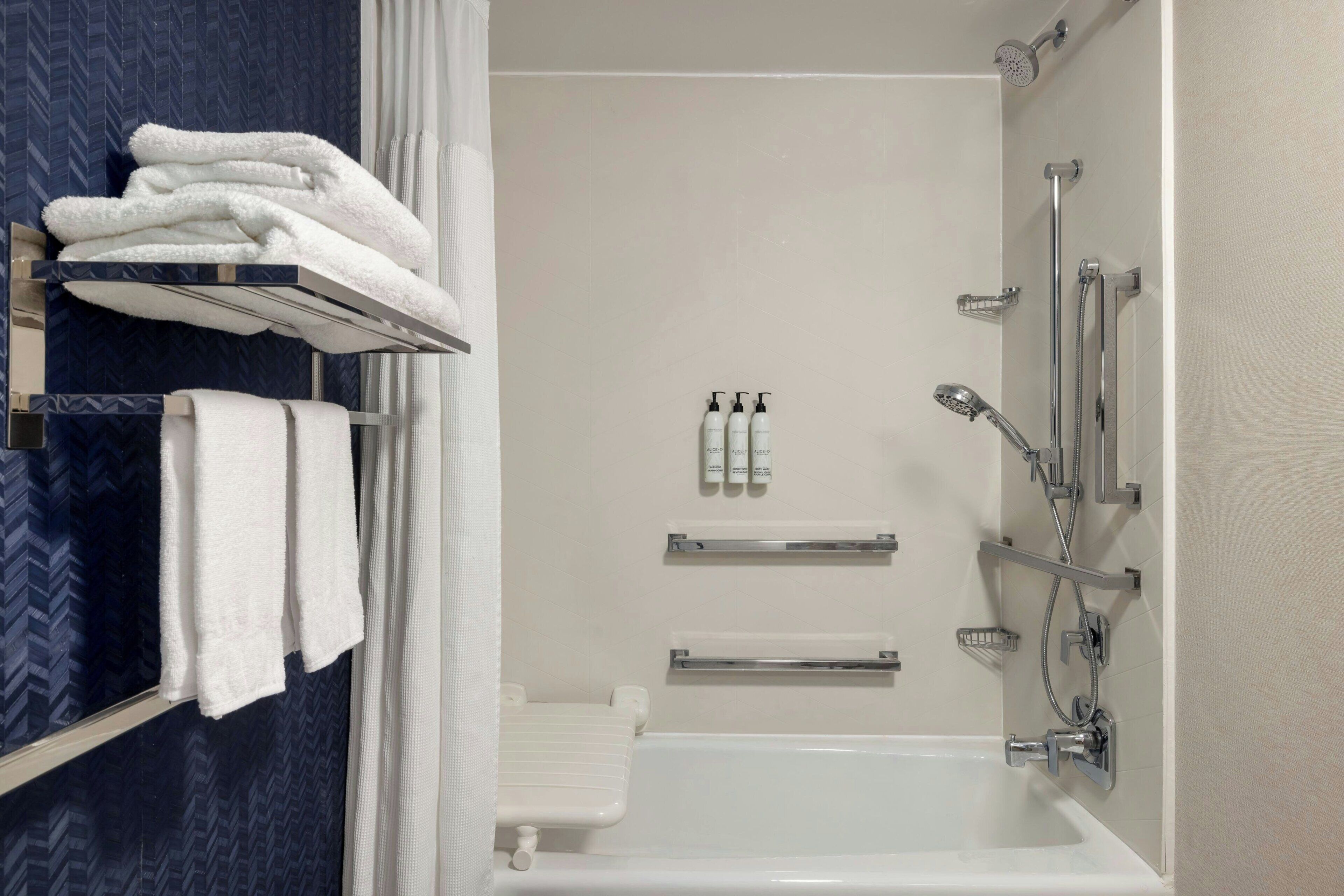 Une salle de bain moderne équipée d’une baignoire, d’une douche et d’un porte-serviettes.