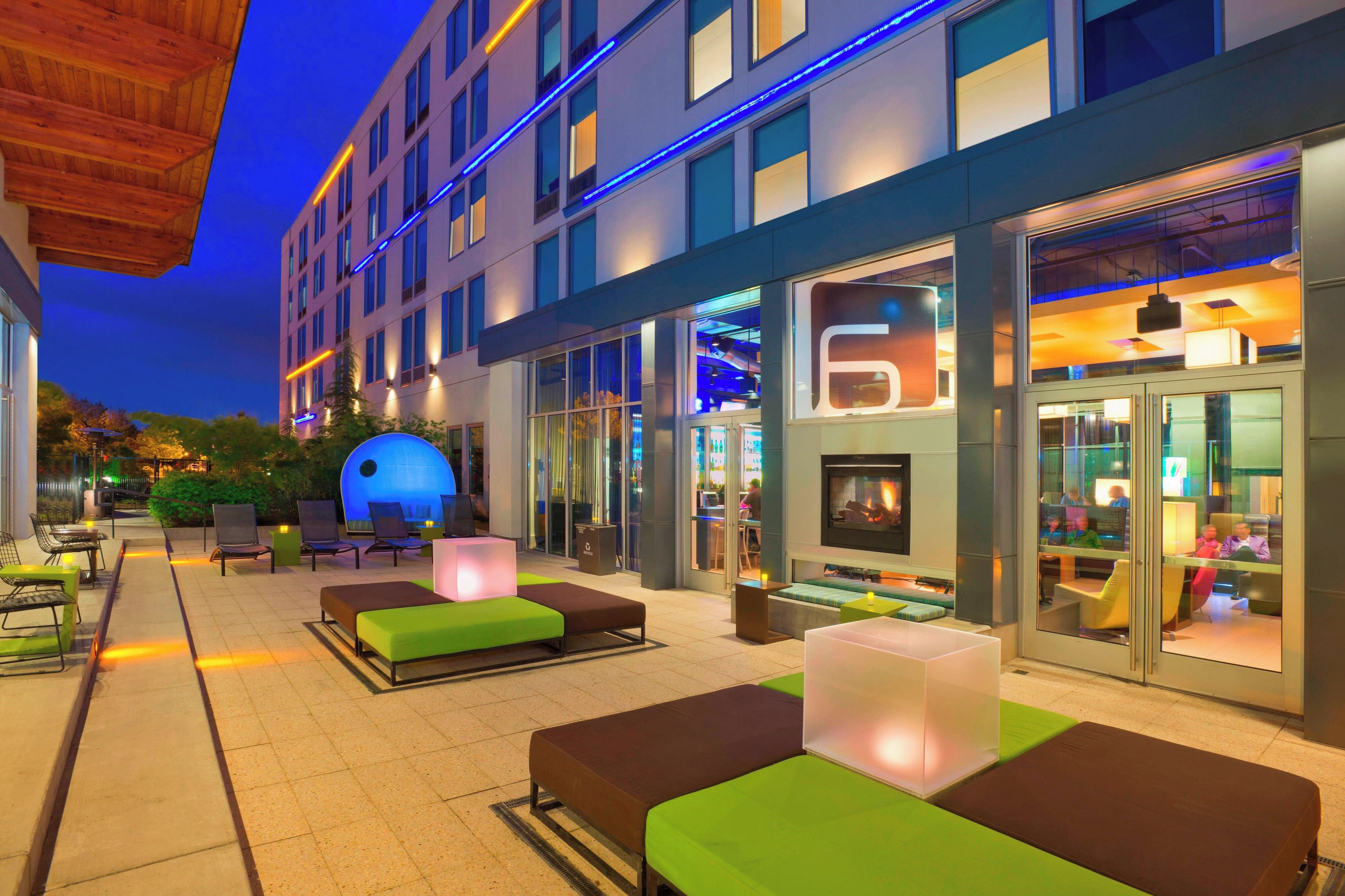 An outdoor seating area with modern furniture and a glass facade building.