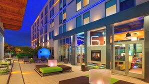 An outdoor seating area with modern furniture and a glass facade building in the background.