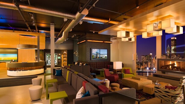 A modern lounge area with seating, a reception desk, and a fireplace.