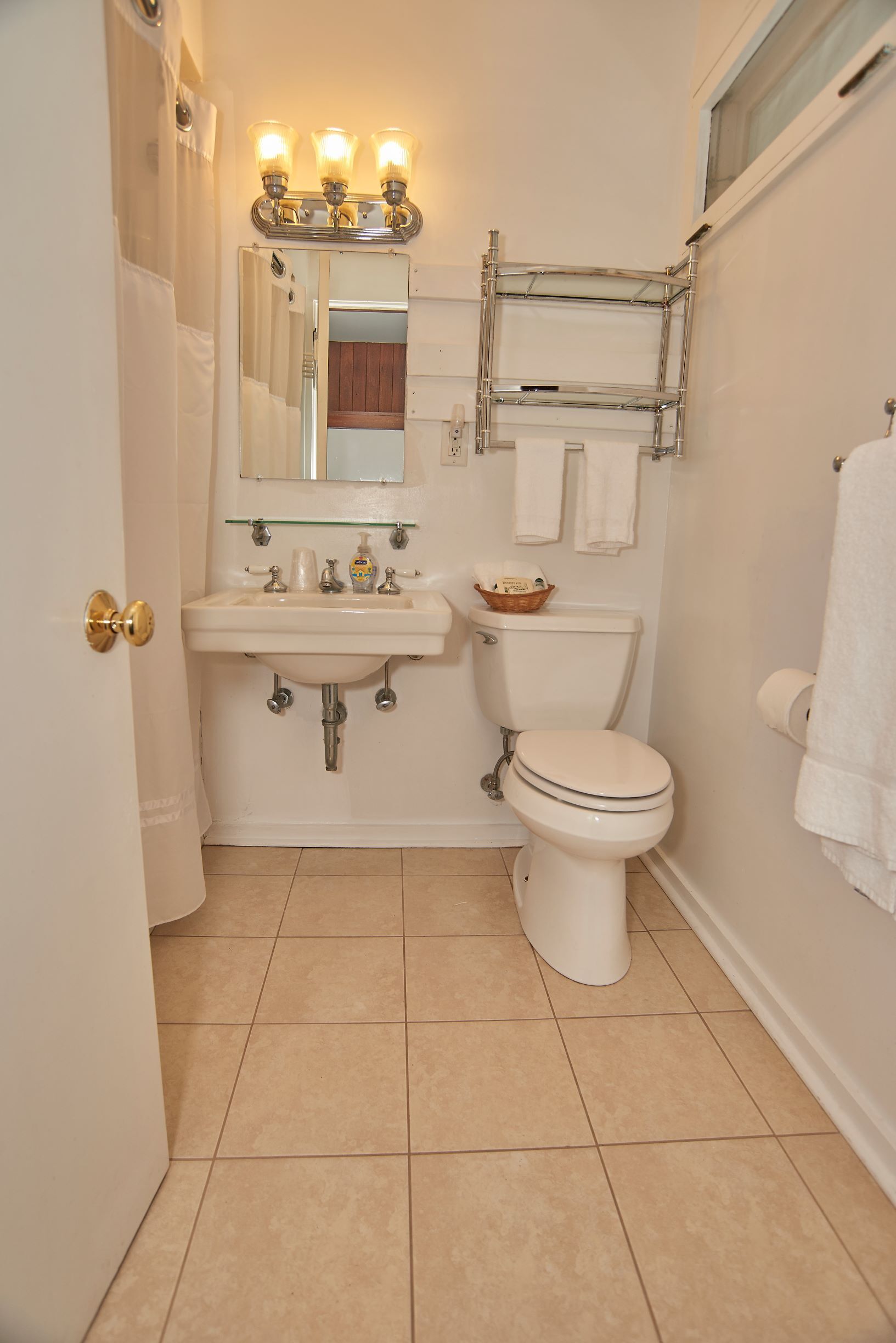 A bathroom with a sink, mirror, and toilet.