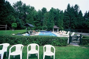 A pool area with lounge chairs and a gazebo.