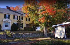A yellow building with a stone wall and a sign for 'DEXTER'S INN & Country Club'.
