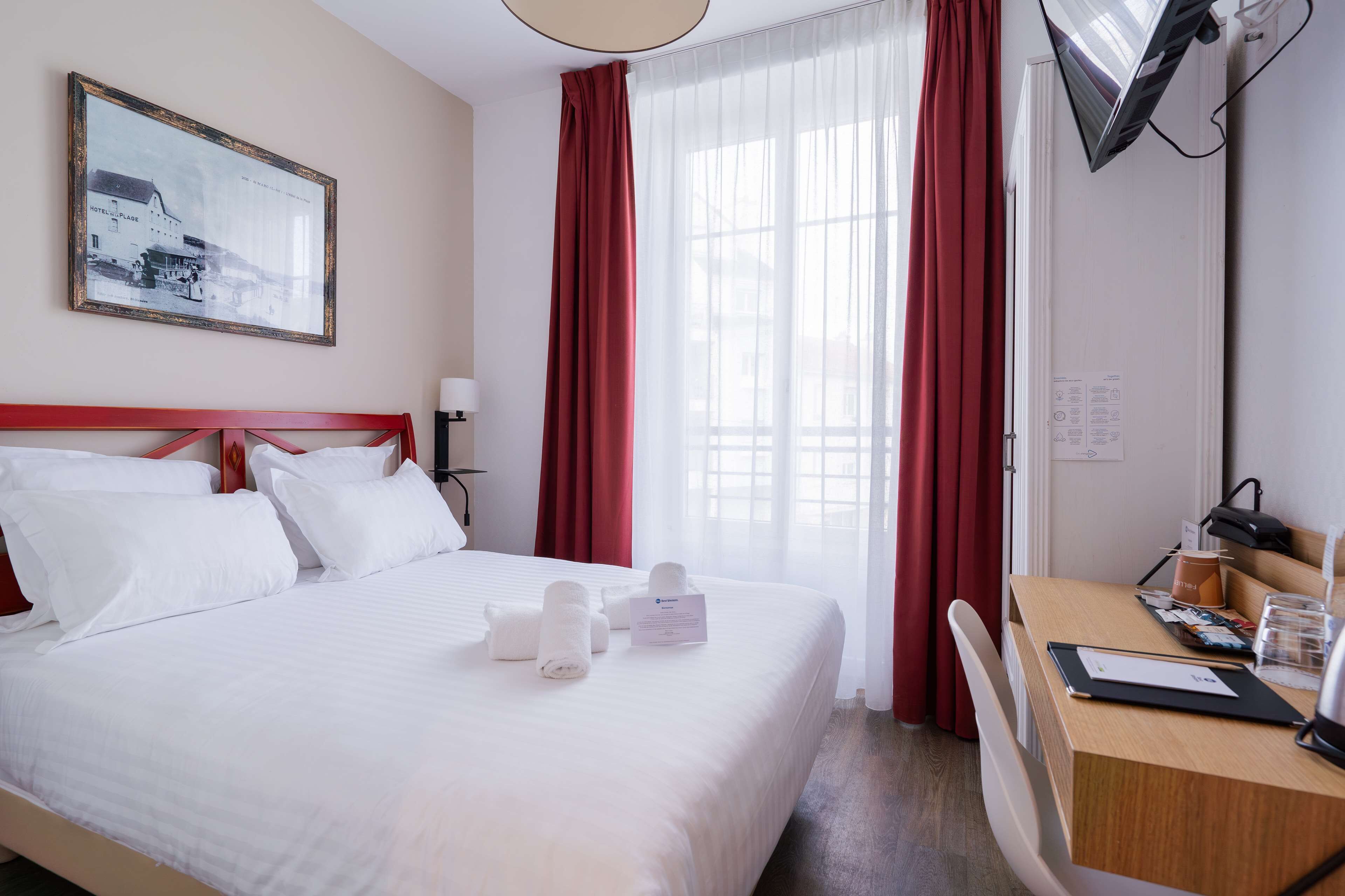 Ein Hotelzimmer mit einem Bett, einem Schreibtisch und einem Sessel.