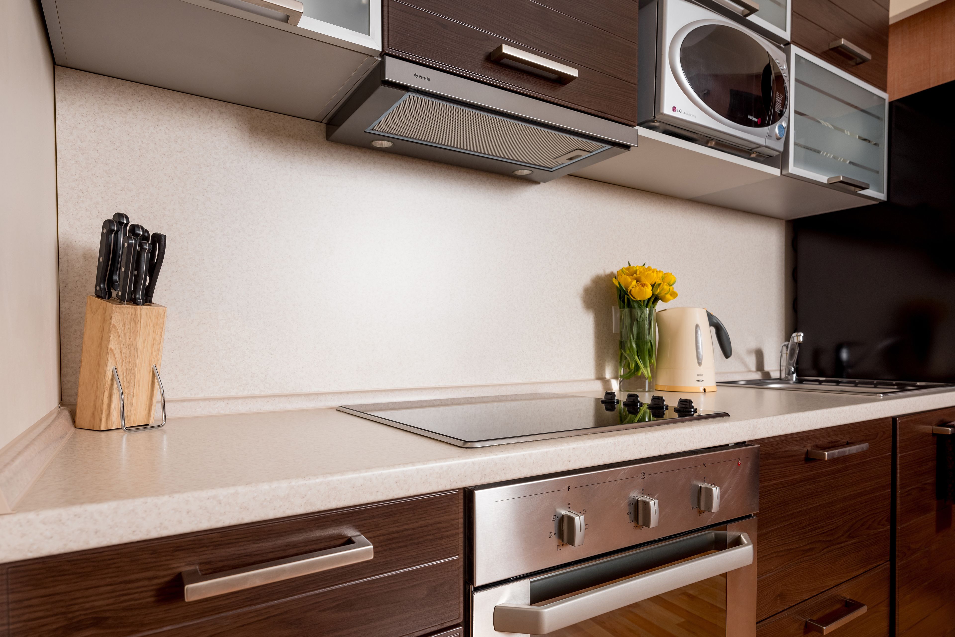 A modern kitchen with a microwave, oven, and built-in cabinets.