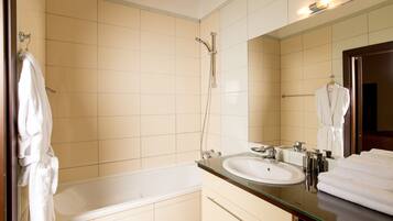 A modern bathroom with a glass-enclosed bathtub, a large mirror, and a white sink.