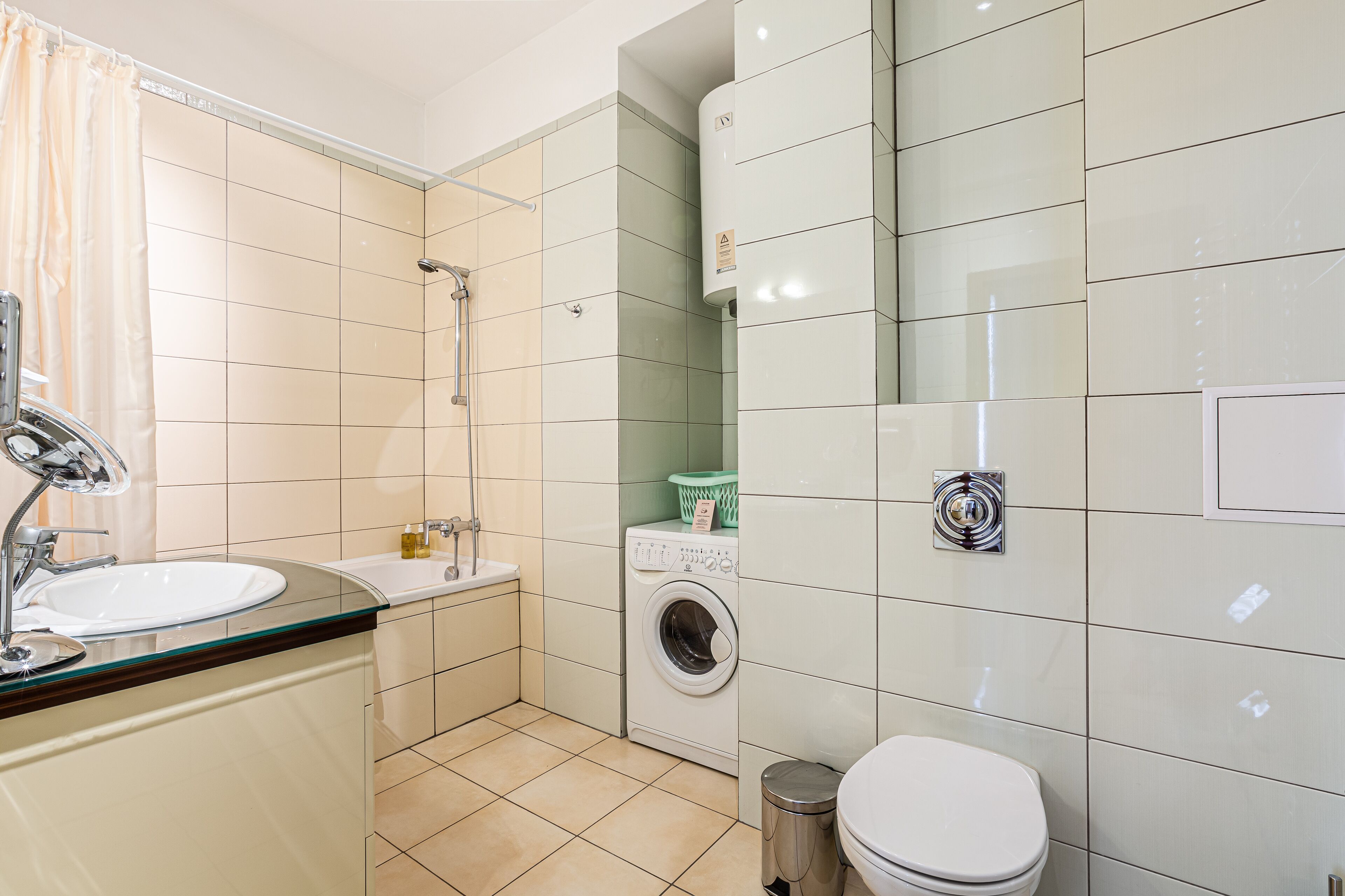 A modern bathroom with a sink, toilet, and washing machine.