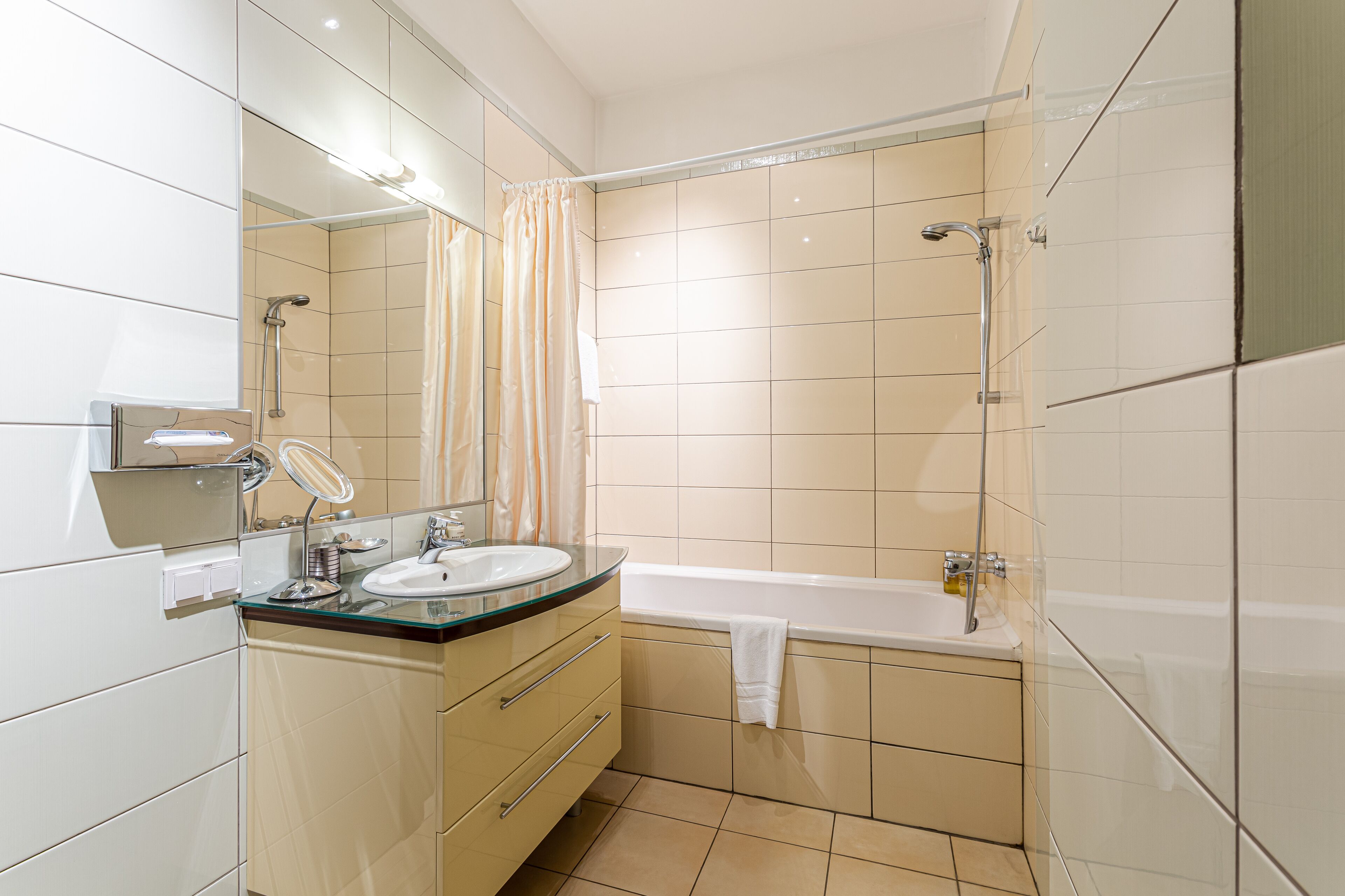 Un baño moderno con ducha envuelta en vidrio, bañera independiente y tocador con espejo y lavabo.