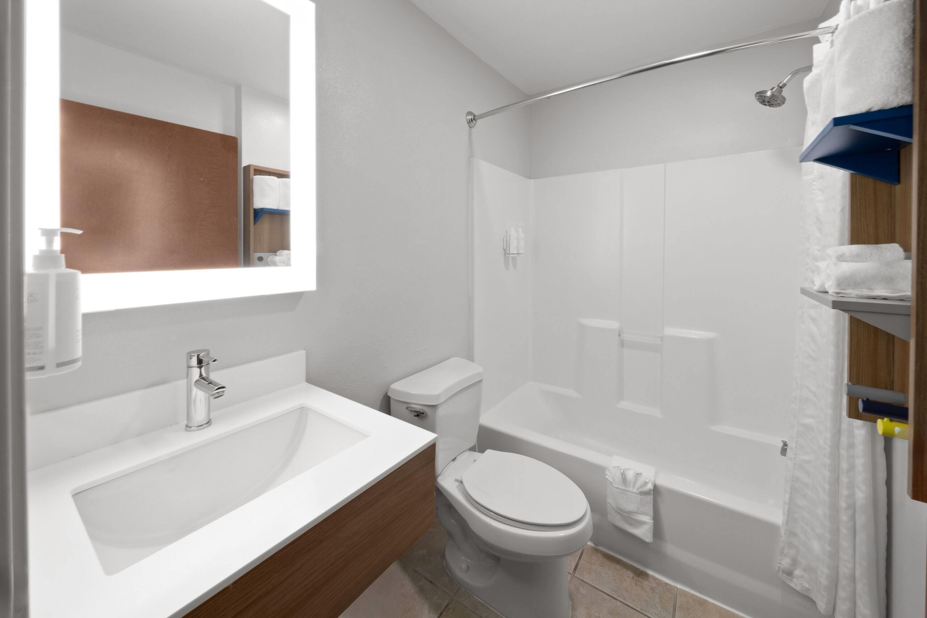 A modern bathroom with a sink, toilet, and shower.