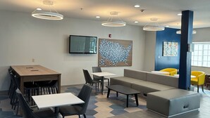 A modern interior with a dining area, seating, and artwork. - Microtel Inn & Suites by Wyndham Baton Rouge Airport (Baton Rouge)