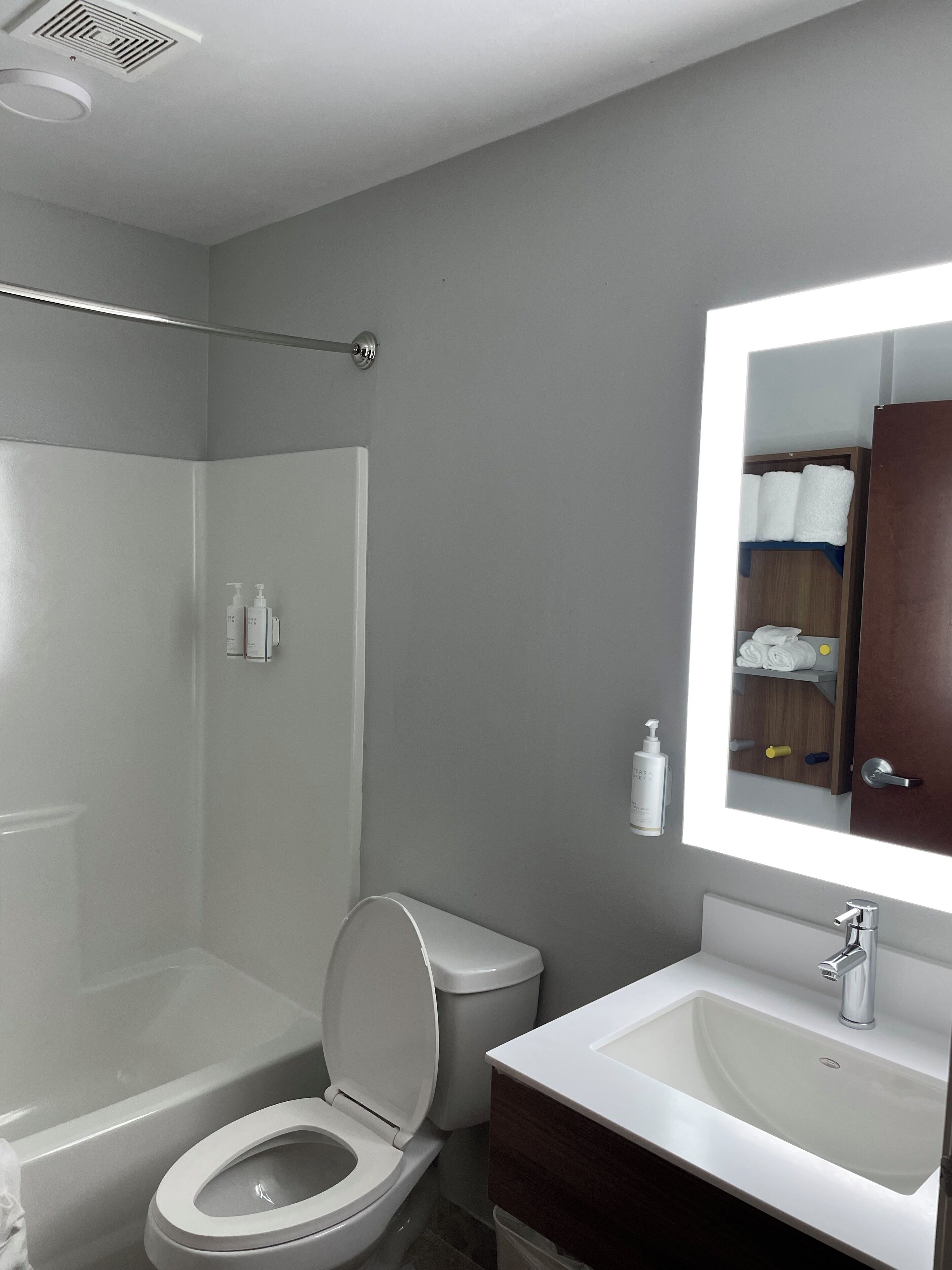 A modern bathroom with a shower, toilet, and sink.