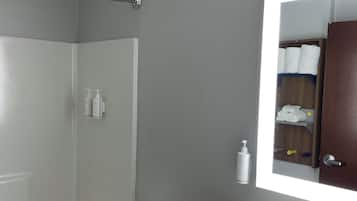 A modern bathroom with a shower, toilet, and sink.