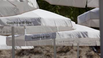 Varias sombrillas blancas con el rótulo 'Sunshine & Spa', señalando un área de spa.