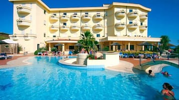 Una piscina al aire libre, sombrillas, sillones reclinables de piscina