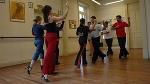 Un cours de danse dans une salle dotée de planchers en bois, d’une barre de ballet et d’œuvres d’art encadrées accrochées aux murs.