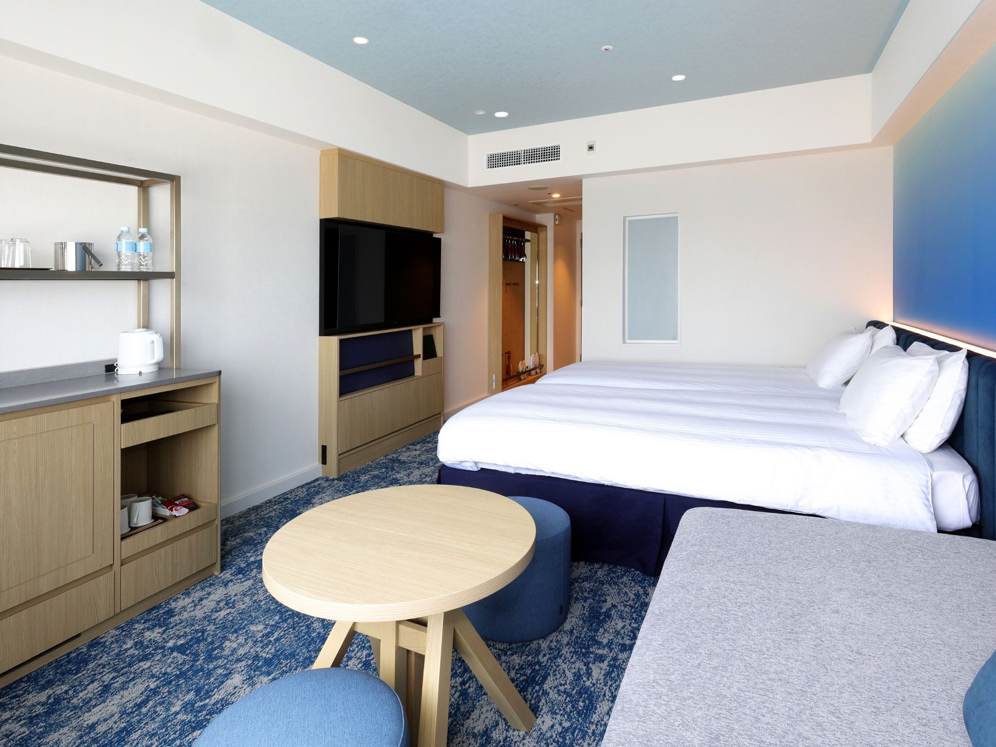 Une chambre d’hôtel équipée d’un lit, d’une télévision, d’une petite table et d’un coin salon.