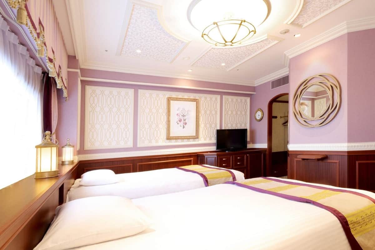 A hotel room with two beds, a television, a mirror, and decorative wall panels.