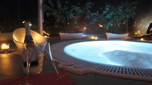 A hot tub with a glass of champagne and a red napkin on a tiled surface. - Hotel Pinar del Mar (Castell-Platja d'Aro)