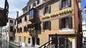 Un bâtiment historique doté d’un balcon et d’une enseigne sur laquelle on peut lire « VISO VINO ».