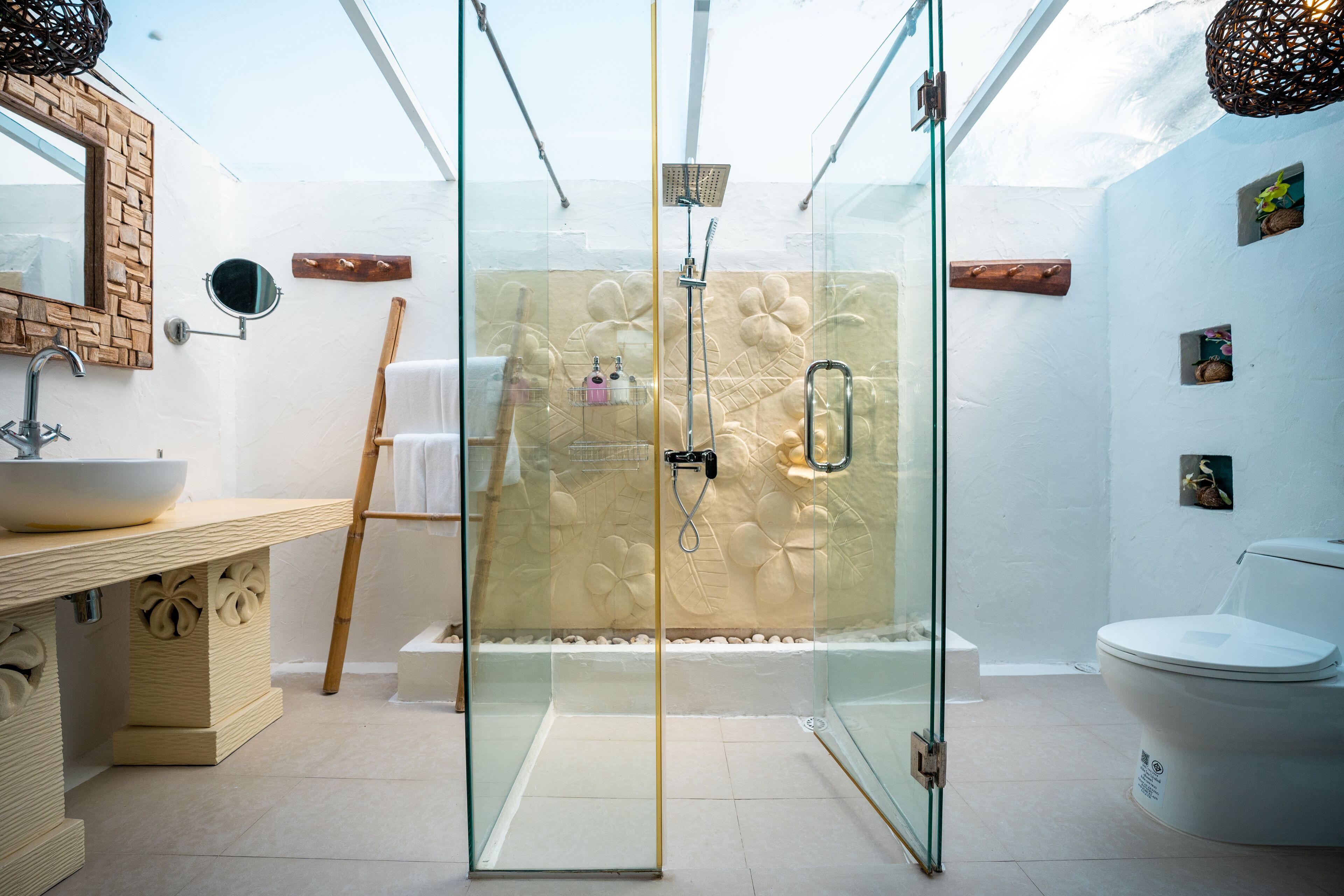 Une salle de bain moderne avec une douche à parois de verre, un meuble-lavabo en bois et des toilettes blanches.