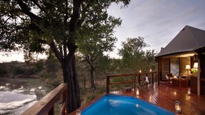 A wooden deck with a swimming pool, surrounded by trees and a view of a natural landscape. - Hamiltons Tented Camp (Bushbuckridge)