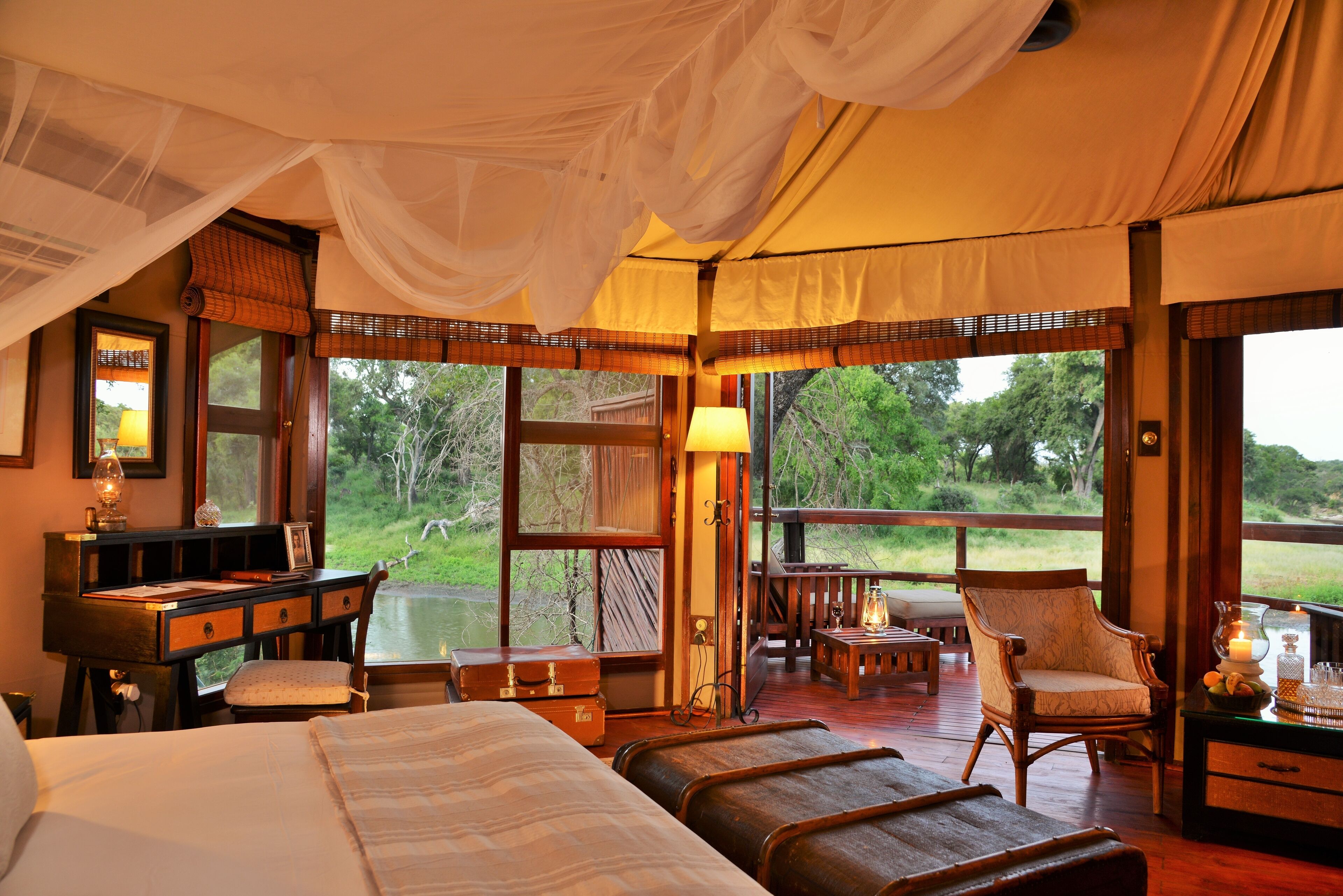 Una habitación con cama, escritorio, silla y vistas al exterior.