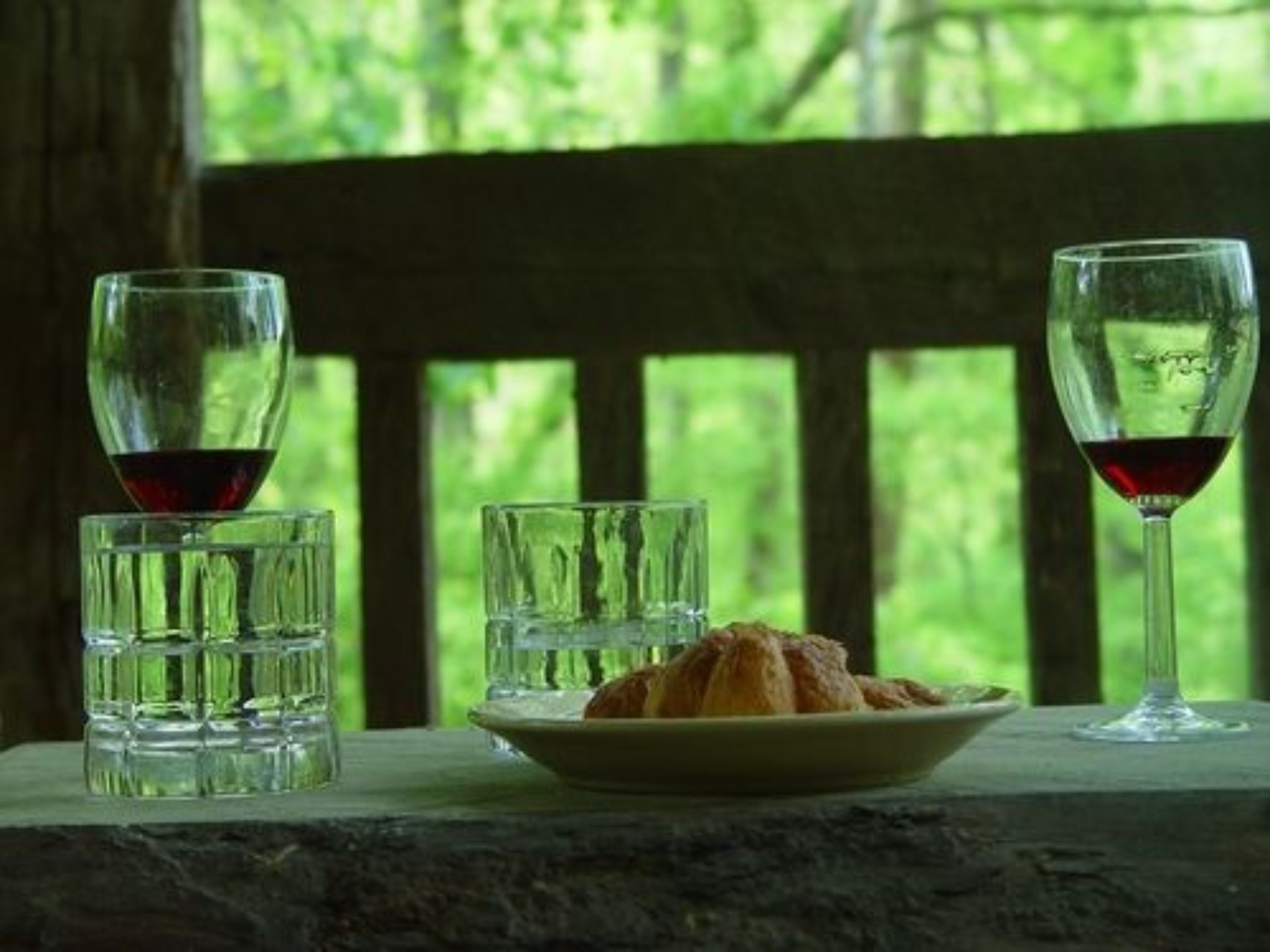 Una mesa con un plato de comida y dos copas de vino.