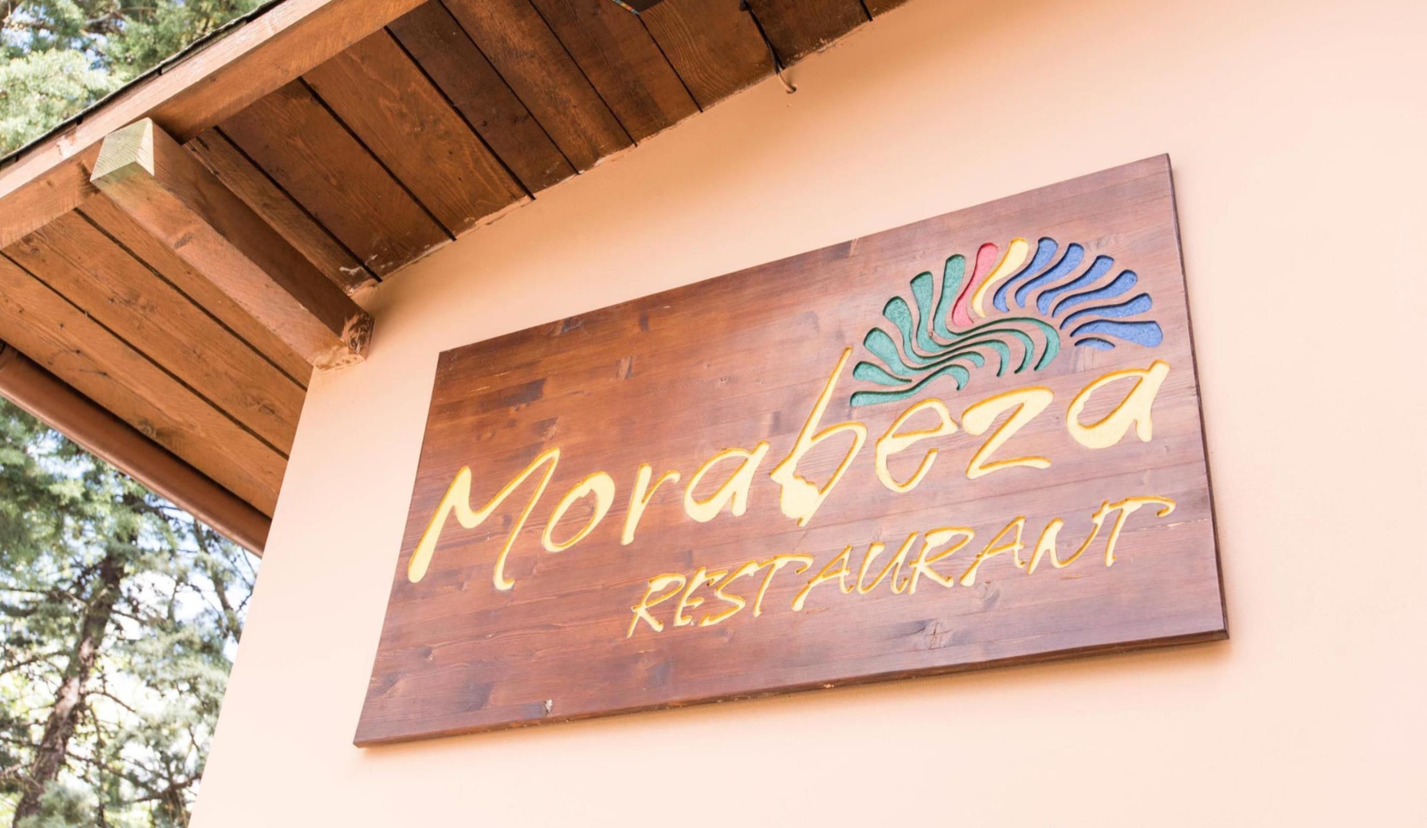 A wooden sign for Morabeza Restaurant with a colorful logo.