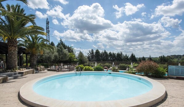 Piscine extérieure en saison, parasols, chaises longues