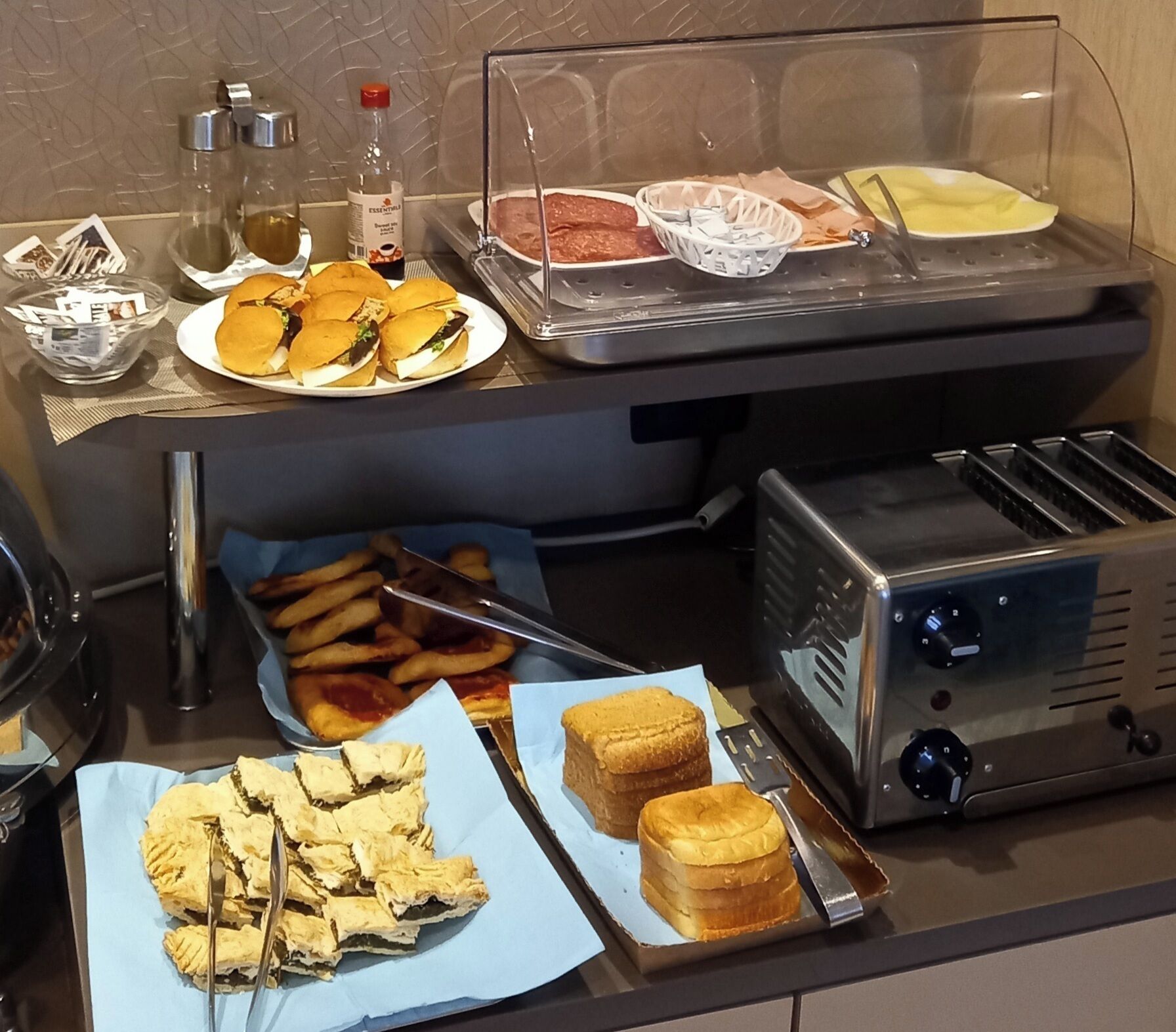 A buffet setup with sandwiches, fries, and desserts.
