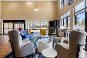 A spacious living room with a large window, a fireplace, and a flat-screen TV.