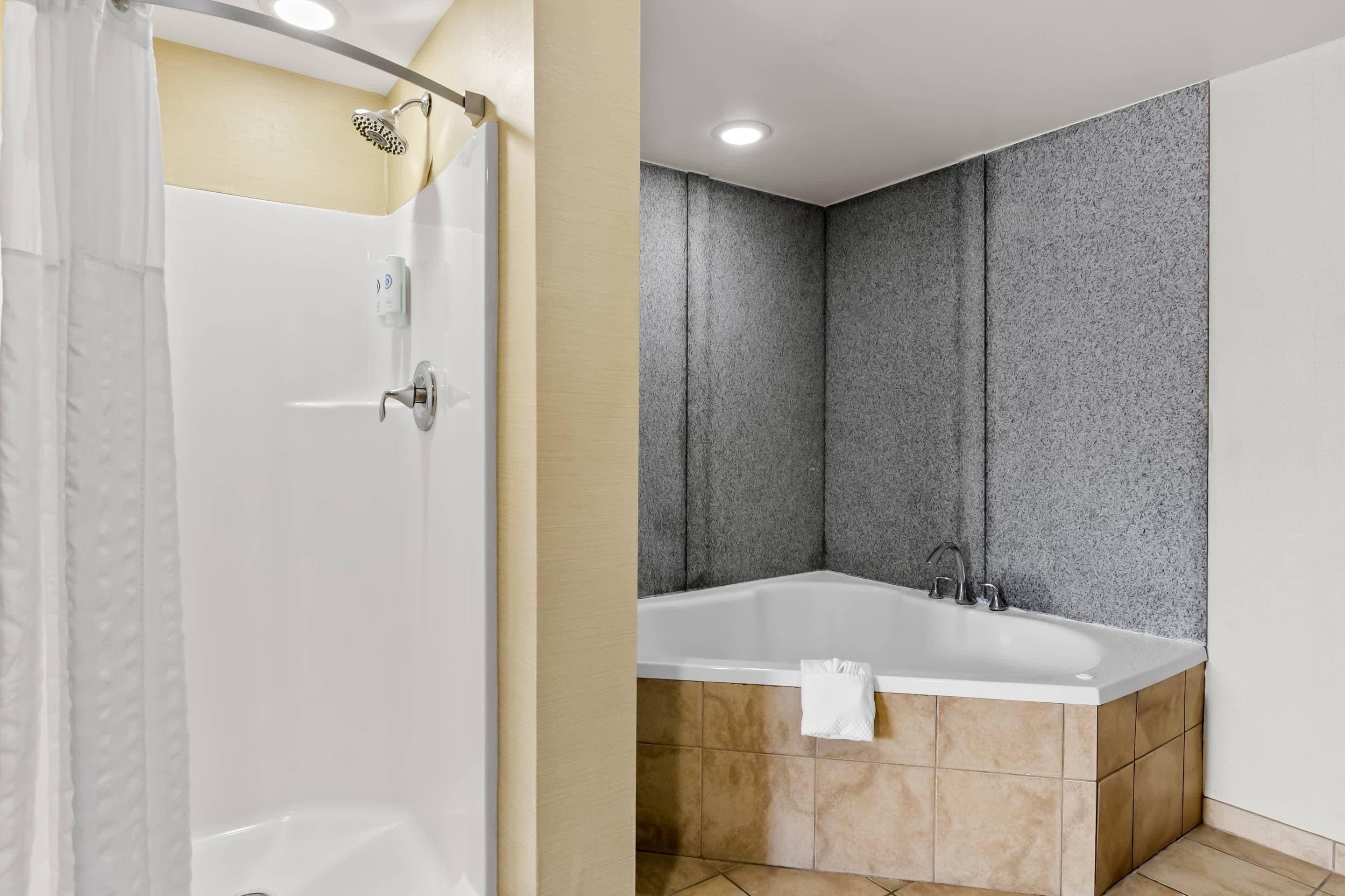 A bathroom with a shower, a bathtub, and a toilet.