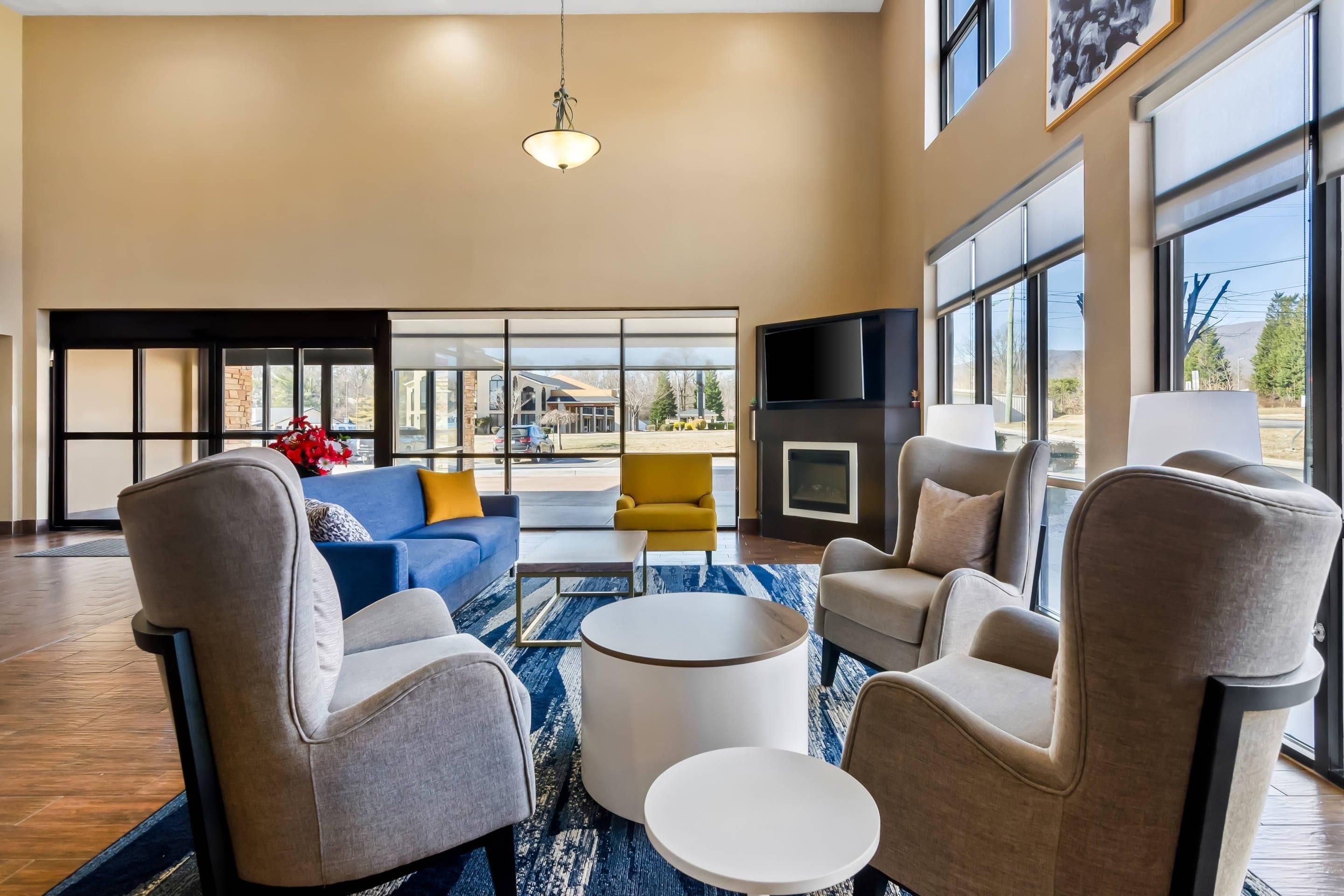 A spacious living room with a large window, a fireplace, and a flat-screen TV.
