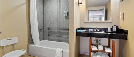 Une salle de bain équipée d’une douche, de toilettes, d’un lavabo et d’un miroir.