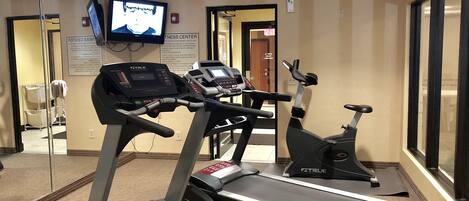 A fitness center with treadmills and an elliptical machine.