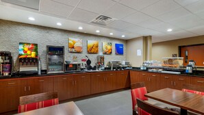A restaurant with a brick wall, wooden cabinets, and red chairs. - Comfort Inn & Suites Montgomery Eastchase (Montgomery)