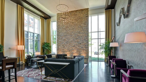 A modern lobby with a stone accent wall, seating area, and large windows.