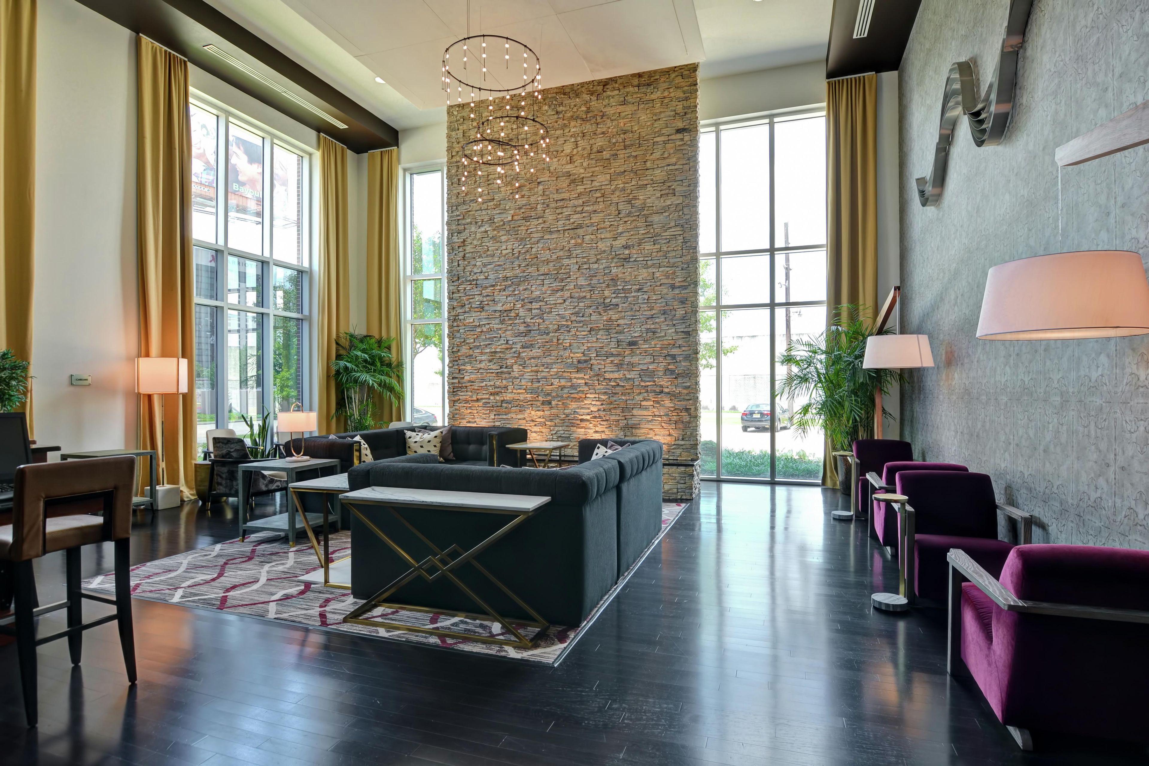 A modern lobby with a stone accent wall, seating area, and large windows.