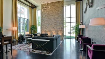 A modern lobby with a stone accent wall, seating area, and large windows.