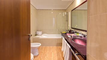 A modern bathroom with a bathtub, a sink, and a toilet.