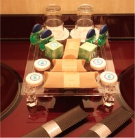 Une sélection de produits de toilette et d’articles de soins personnels est présentée sur une table en verre.