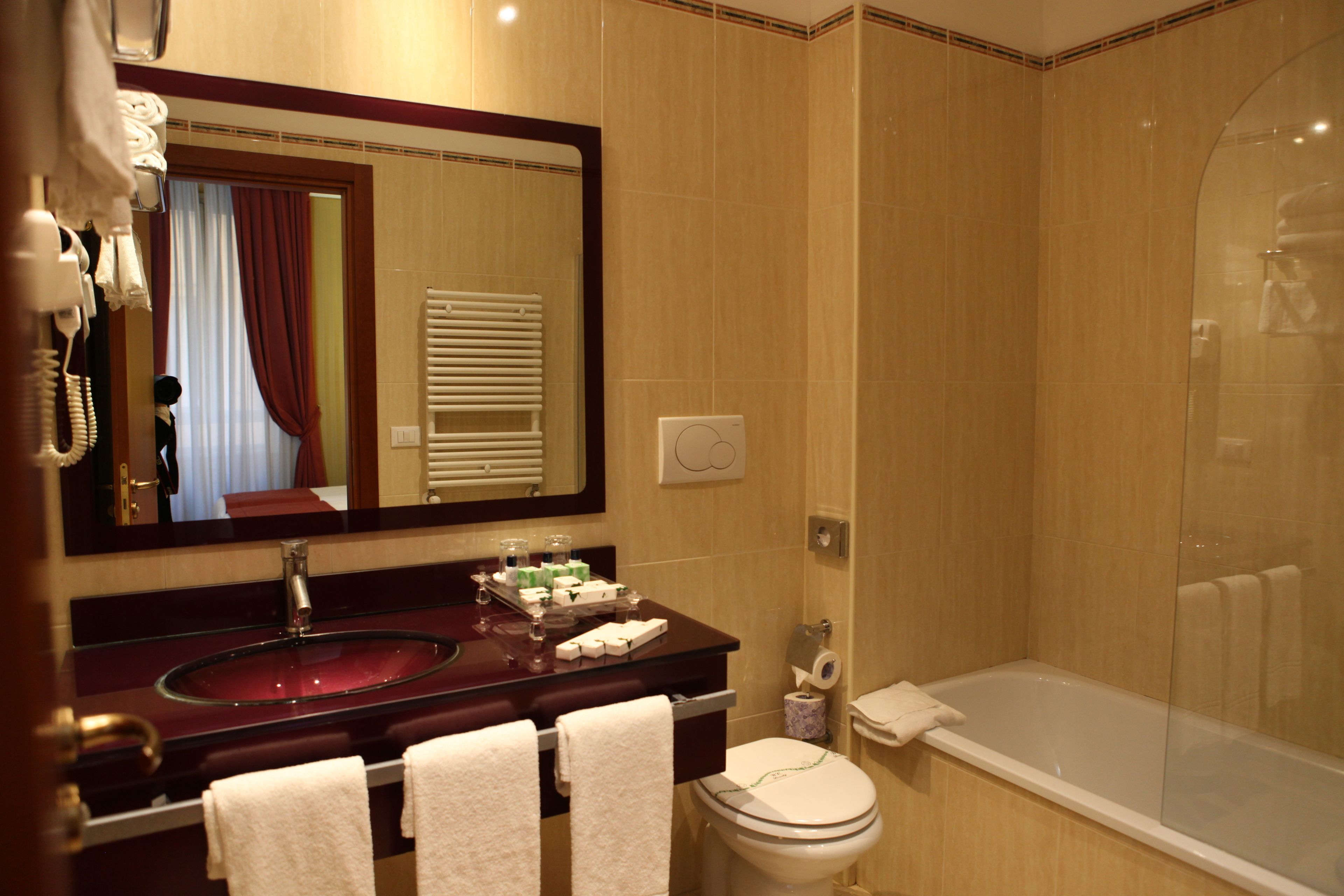 Une salle de bain équipée d’un lavabo, d’un miroir, de toilettes et d’une baignoire.
