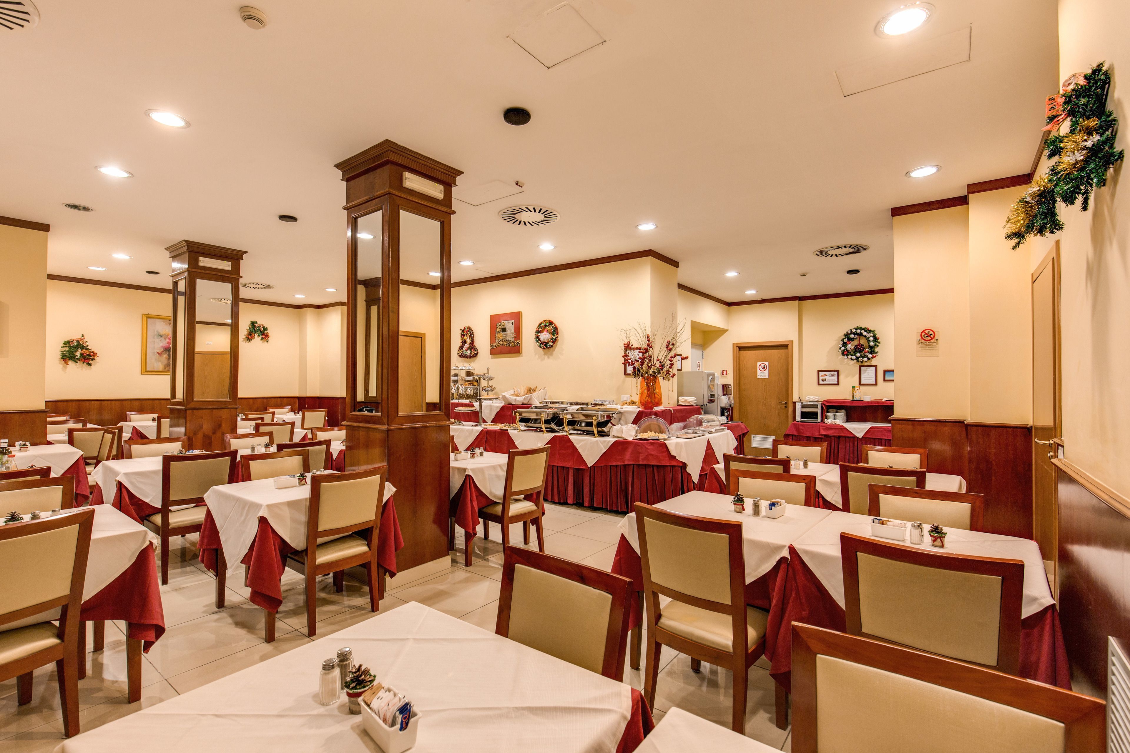 A dining area with multiple tables and chairs, a central buffet, and a mirror on the wall.