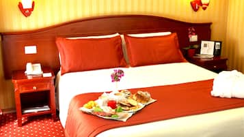 A hotel room with a neatly made bed, a bedside table with a lamp, and a tray of breakfast items on the bed.
