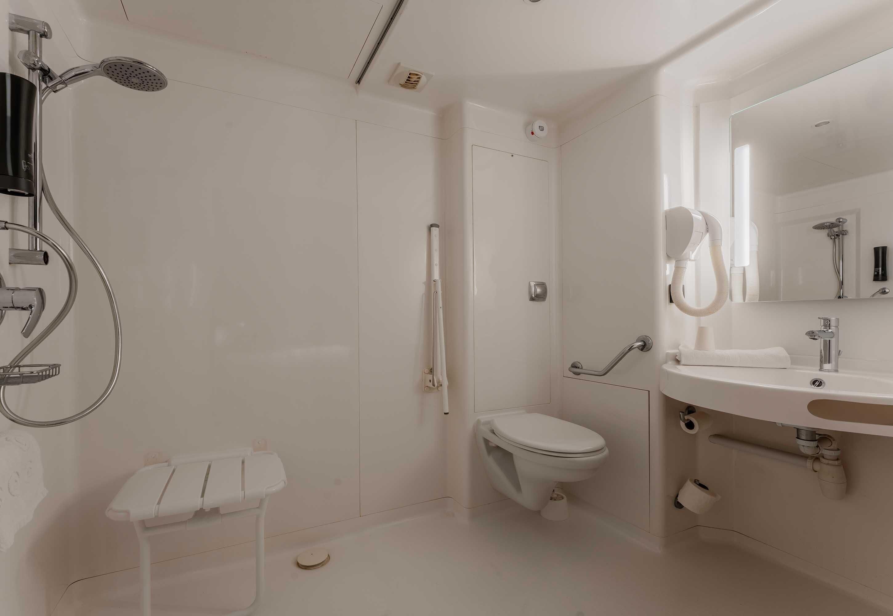Une salle de bain moderne équipée d’une douche, de toilettes et d’un lavabo.
