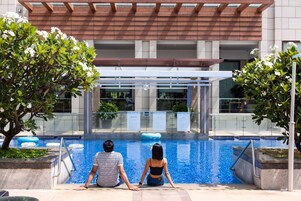 Una piscina al aire libre, camas de piscina gratis, sombrillas
