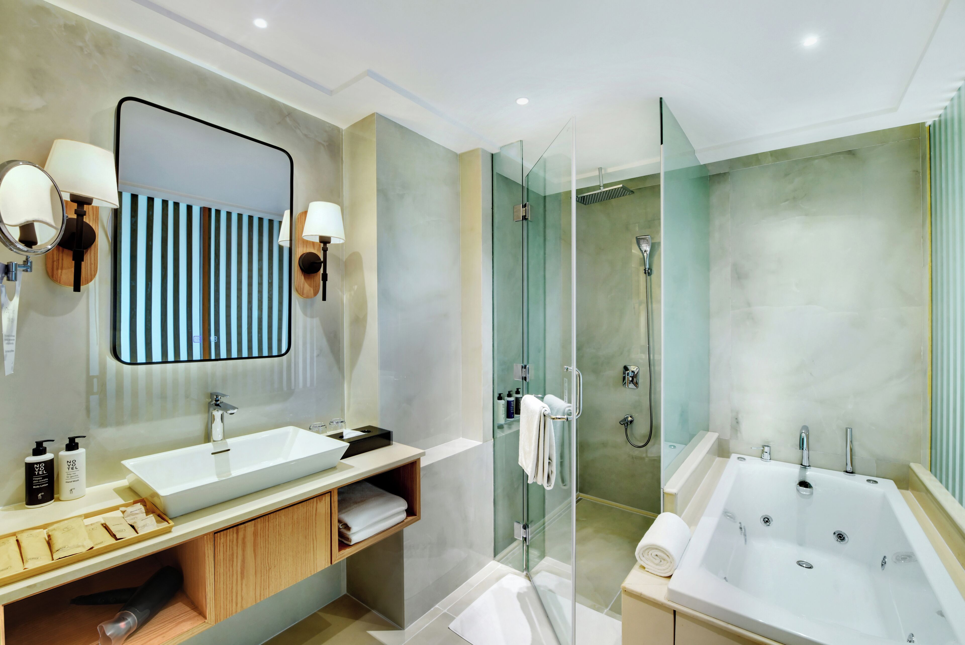 Un baño moderno con un espejo grande, dos lavabos, una ducha y una bañera.