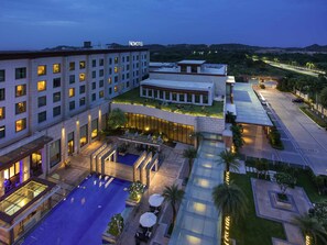 A hotel with multiple floors, outdoor pool, and landscaped areas. - Novotel Hyderabad Airport Hotel (Hyderabad)